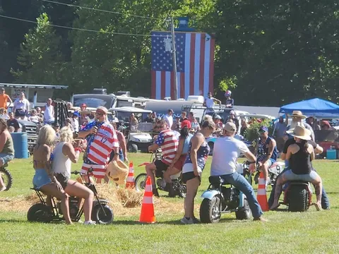 A lineup of custom mini bikes in front of the giant American flag before the parade